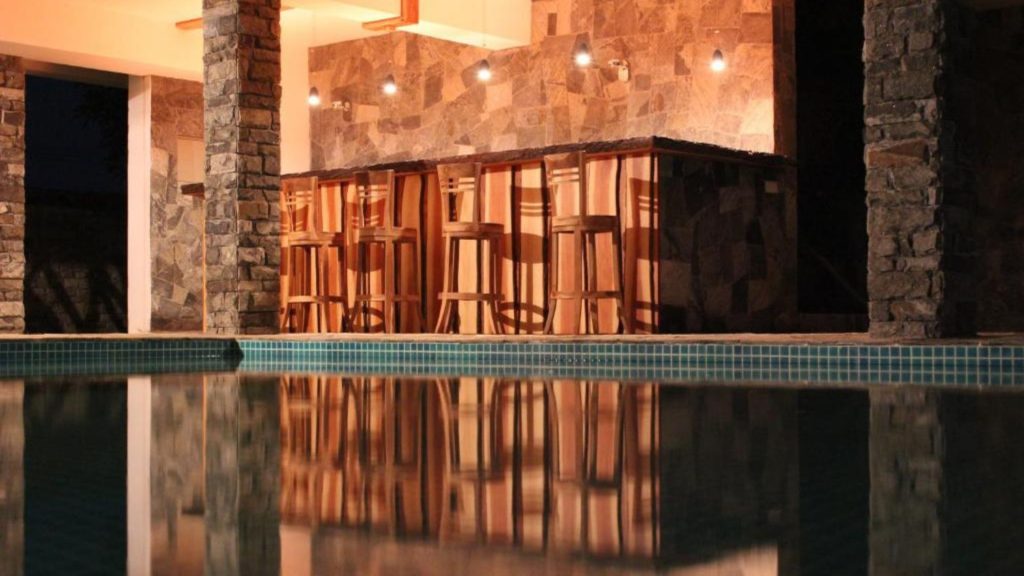 Beleuchteter Pool am Abend mit warmem Licht und spiegelnder Wasseroberfläche