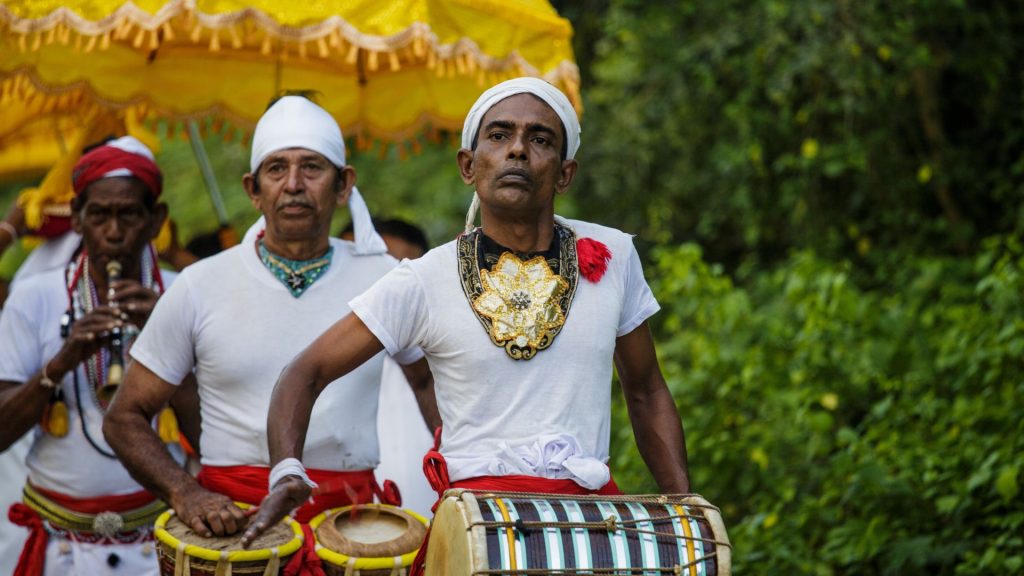 Buddhistische Prozession mit Mönchen, einem Kind und gelbem Schirm im warmen Tageslicht - Einweihung vom Thaulle Resort Sri Lank