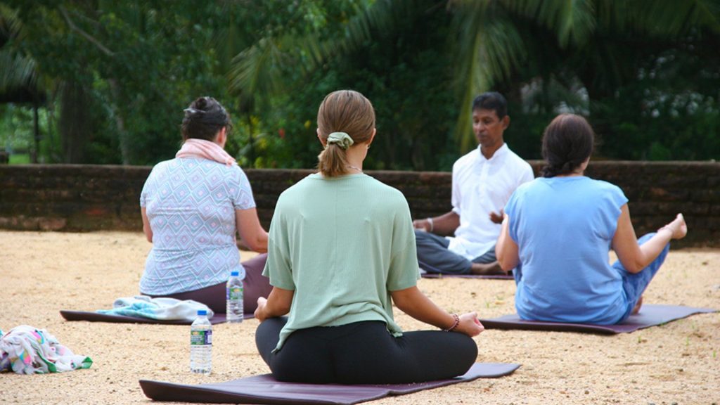 Gäste bei einer geführten Yoga-Stunde im Freiluft-Pavillon des Thaulle Resorts