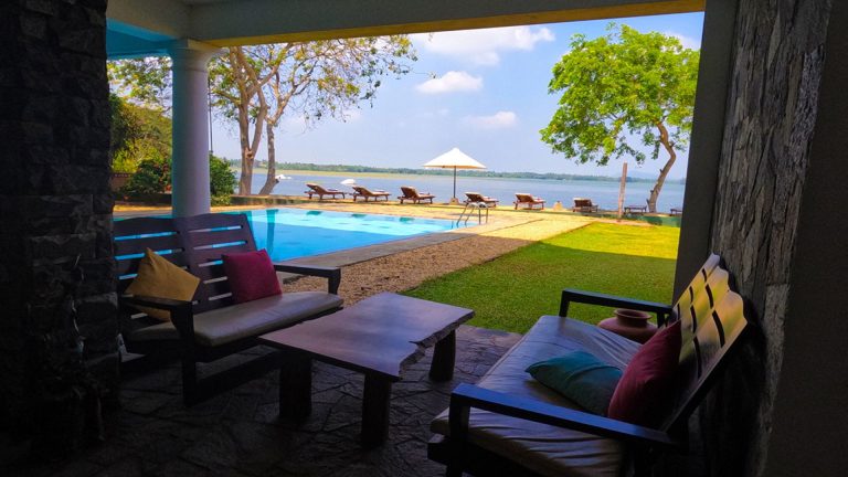 Offener Sitzbereich mit Blick auf Pool, Garten und See im Thaulle Resort