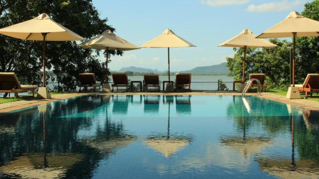 Pool mit Sonnenschirmen und direktem Blick auf den See