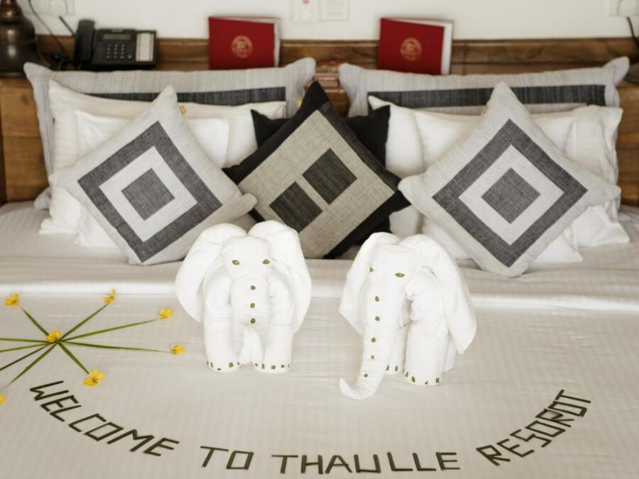 Bett mit Handtuch-Elefanten und Willkommensgruß im Thaulle Resort