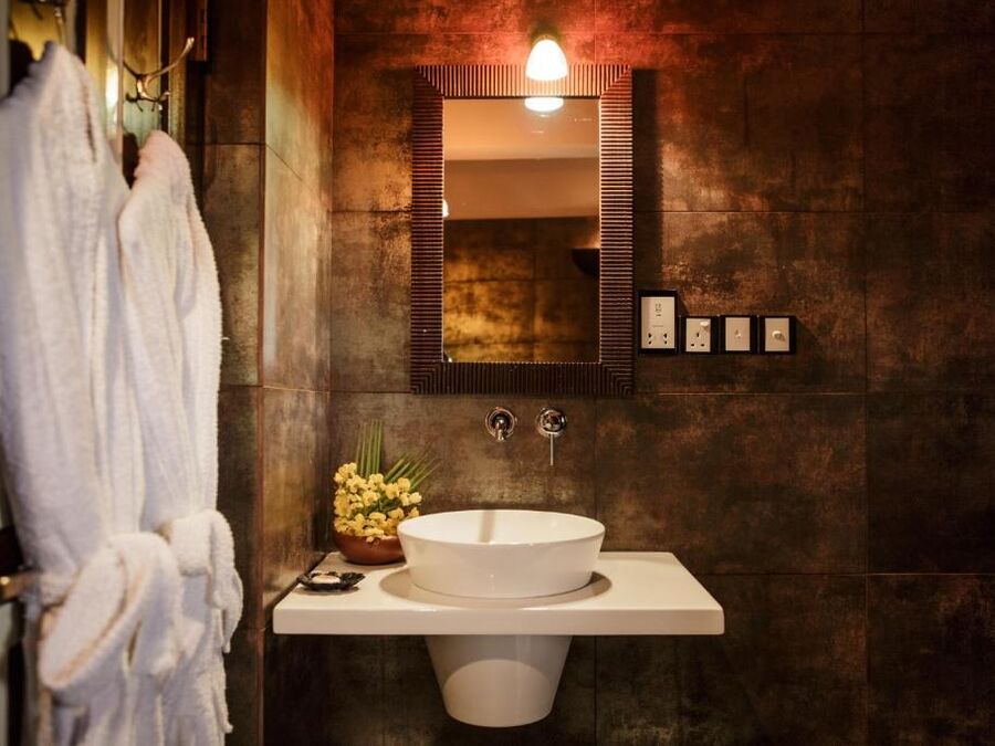 Badezimmer der Junior Suite mit Waschtisch und Bademänteln