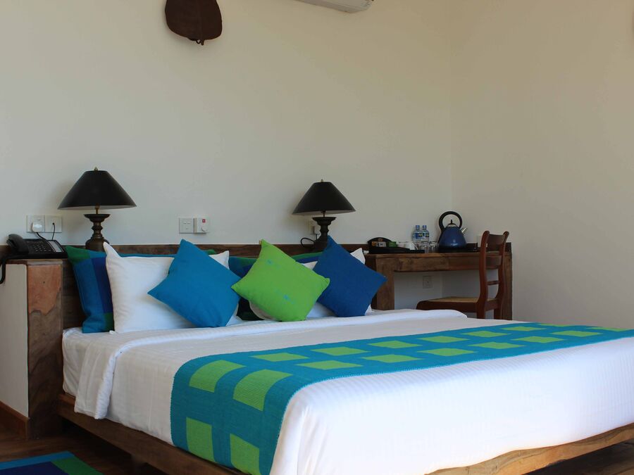 Helles Superior-Zimmer mit Kingsize-Bett und blau-grünen Kissen