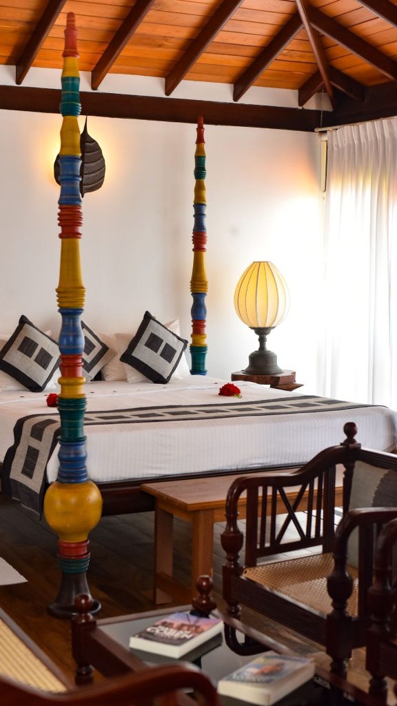 Schlafzimmer der Junior Suite mit Himmelbett und geschnitzten Holzsäulen im Thaulle Ayurveda Resort